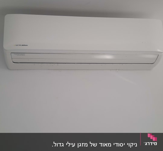 מזגן קיר לבן מותקן על קיר אפור